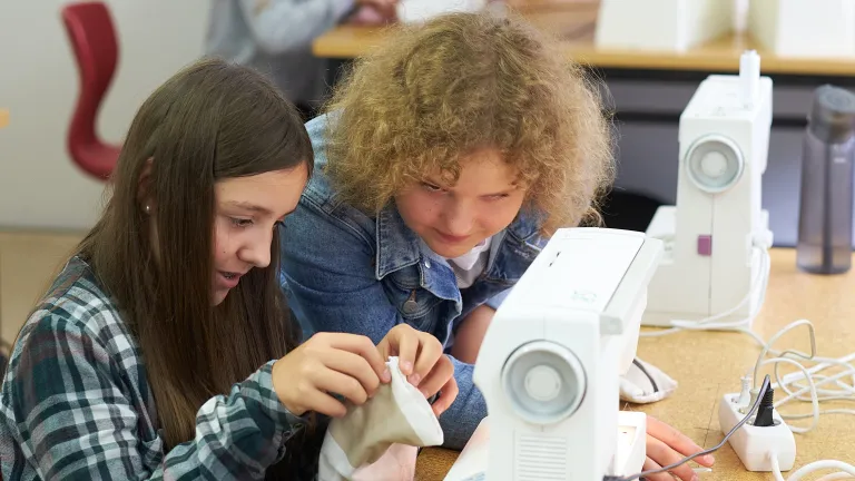 Zwei Schlerinnen an der Nhmaschine