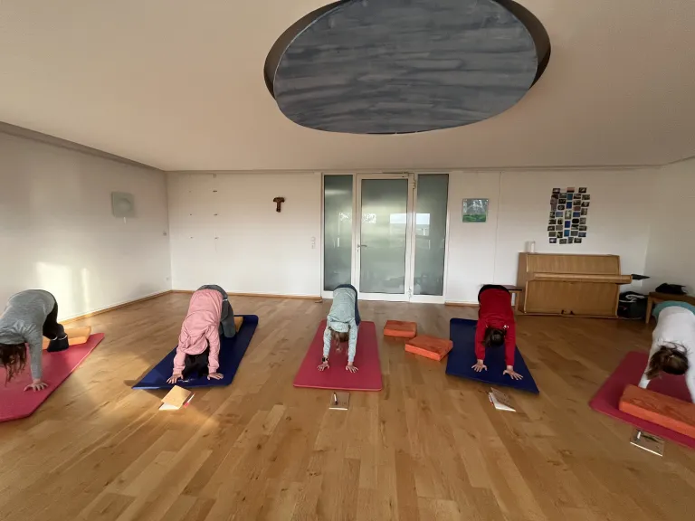 Fünf Kinder machen Yoga in unserem Meditationsraum.