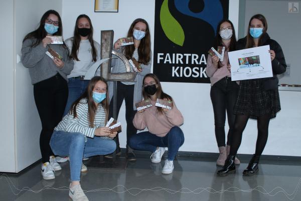 Schüler zeigen stolz das Fairtrade-Siegel der Schule