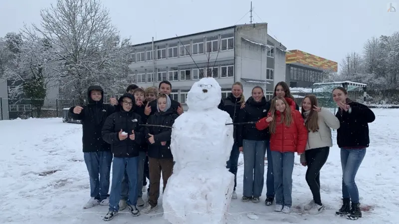 Schülergruppe mit Schneemann