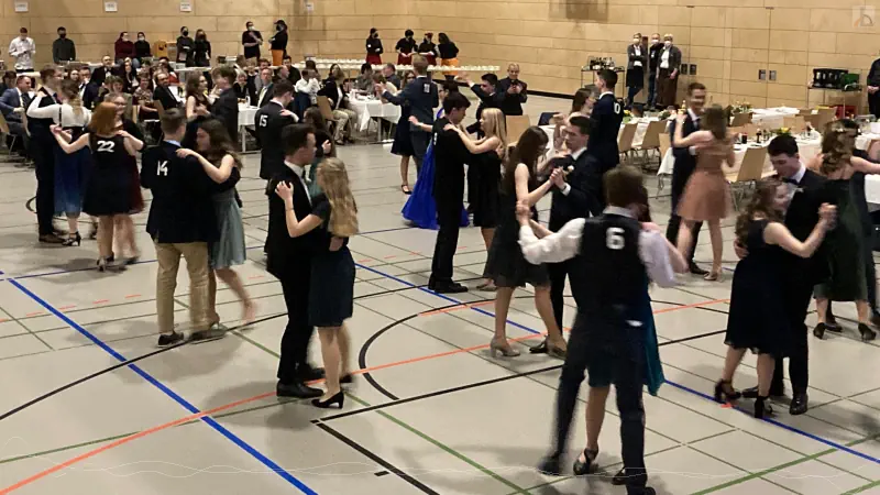 Mehrere Schülerpaare tanzen in der Turnhalle