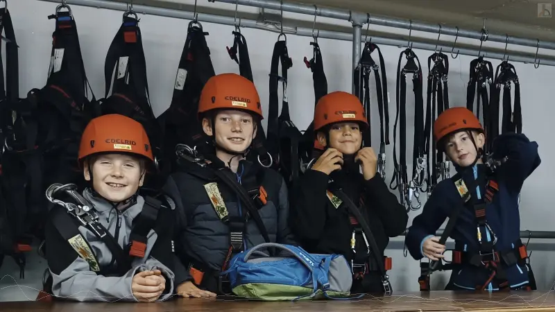 Vier Schüler in Kletterausrüstung