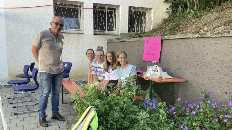 Herr Eisen mit Schlerinnen vor Blmchen