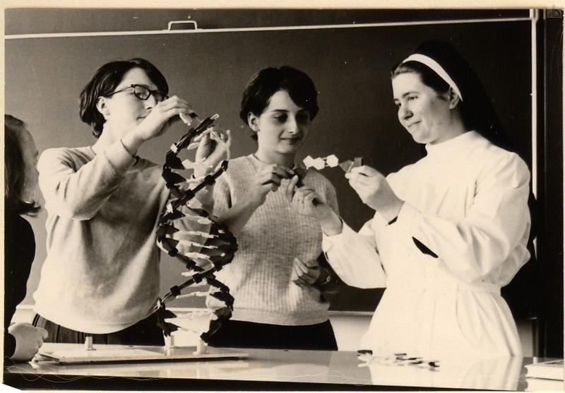 Zwei Schülerinnen und Nonne experimentieren in Chemie
